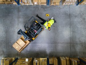 Worker helps a colleague injured after a forklift accident