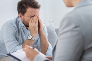 Man suffering from anxiety speaking to a psychiatrist