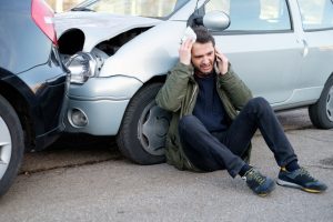 A man holding his head after a car crash.