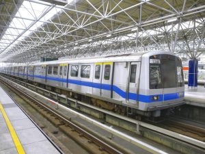 a silver and blue train parked at a train station platform