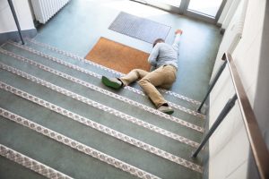 Injured man lying at bottom of stairs after a slip and fall accident