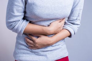 Woman suffering painful periods holding stomach.