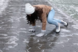 Woman slipping with hands on ice.